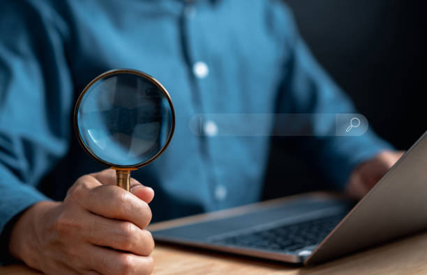 istock Businessman use magnifying glass Search On Virtual Screen Data Search Technology Search Engine Optimization. Man use computer to Searching for information. Using Search Console for data. 1451865955