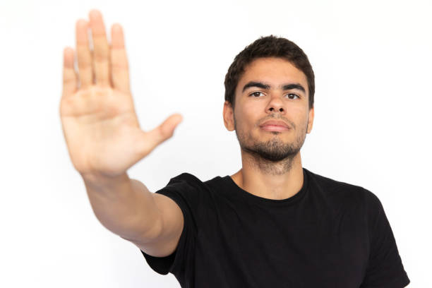 istock Serious young man showing stop sign 1451866544