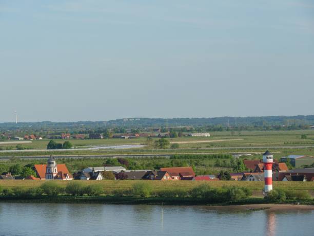 istock Lighthouse on the Elbe river bank with dense trees in Hamburg, Germany 1451866607