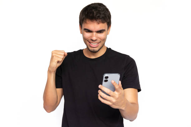 istock Happy young man using phone with clenched fist 1451868615