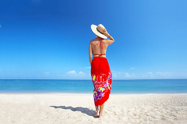 woman in red view of  female back on a background of the tropical sea sarong stock pictures, royalty-free photos & images