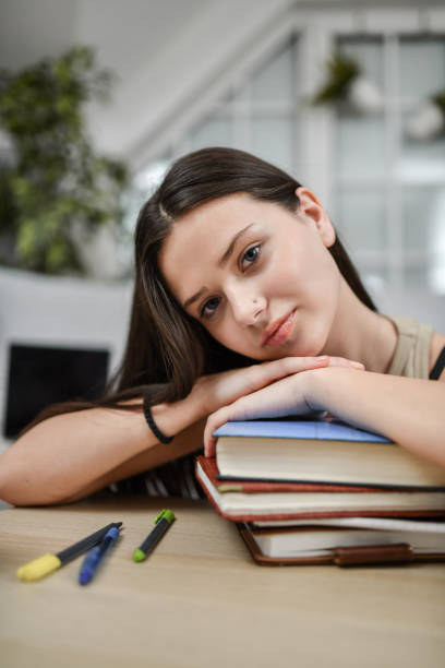 istock Cute Female Student Taking Break From Studying And Resting On Books 1451870826