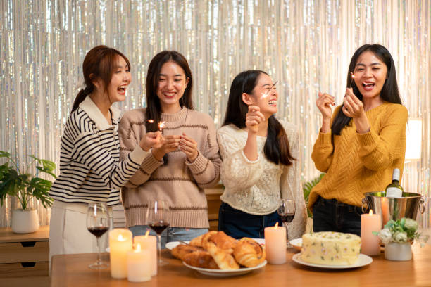 istock Young beautiful woman holding sparkler lights firework with enjoying in night while dinner to celebrating in new year party festive at home 1451873496