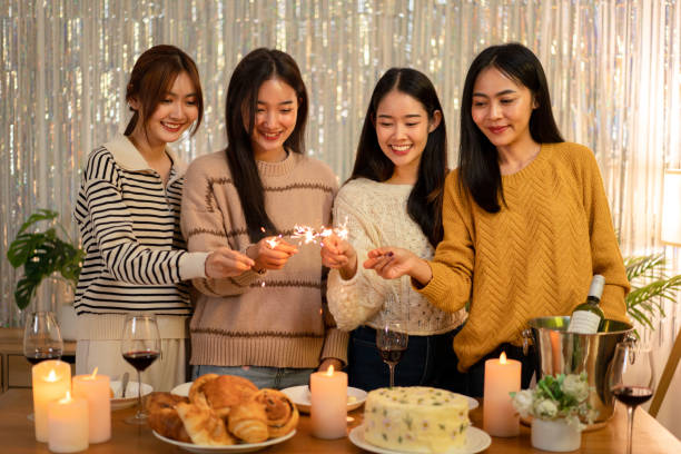 istock Young beautiful woman holding sparkler lights firework with enjoying in night while dinner to celebrating in new year party festive at home 1451873593