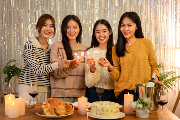 istock Young beautiful woman holding sparkler lights firework with enjoying in night while dinner to celebrating in new year party festive at home 1451873709