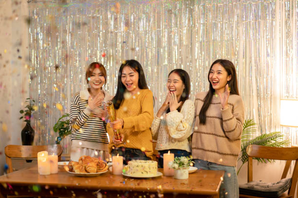 istock Young beautiful woman playing and pull poppers confetti party with enjoying while celebrating in new year party at home 1451873730