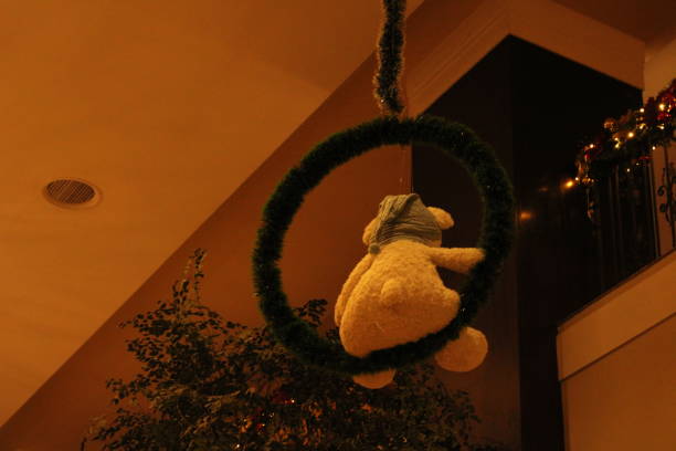istock Teddy Bear in a Wreath Suspended from the Ceiling 1451874858