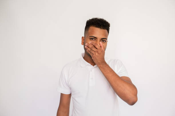 istock Serious young man covering his mouth with hand 1451875514