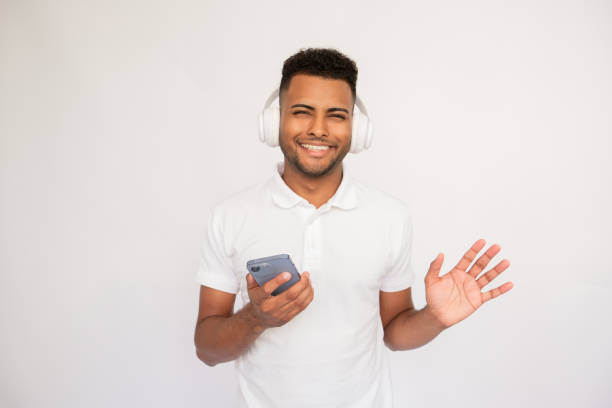 istock Cheerful young man in headphones using smartphone 1451880788