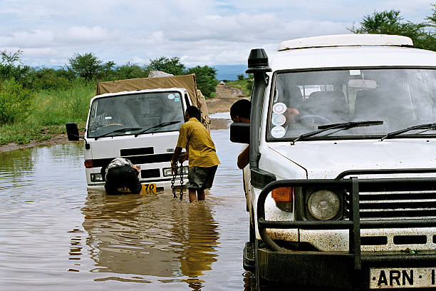 vehicle stuck in a flood vehicle stranded in a flooded road in africa waist deep in water stock pictures, royalty-free photos & images