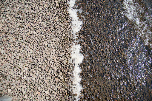 Stone shore divided on a river and dry sides.