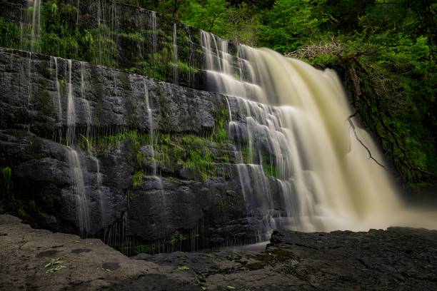 istock Waterfall in Brecon, Wales surrounded with green trees 1451894739