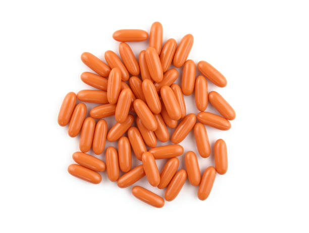 istock Oval orange capsules on a white background. 1451895756