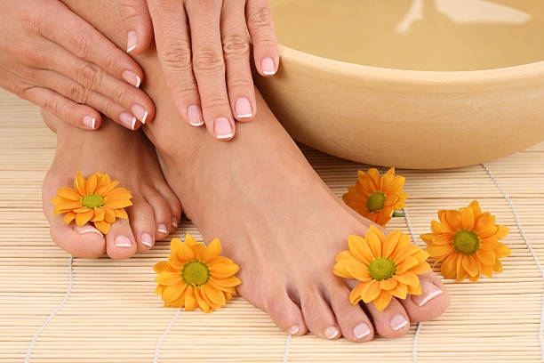istock Manicured hands and feet next to a bowl and flowers 145189680