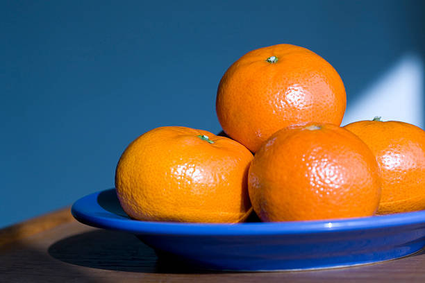 Oranges on a blue plate stock photo