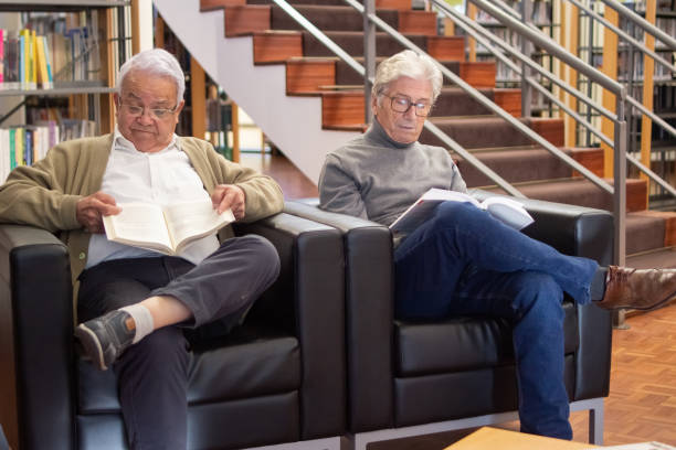 istock Serious elderly men busy with reading in library 1451902693