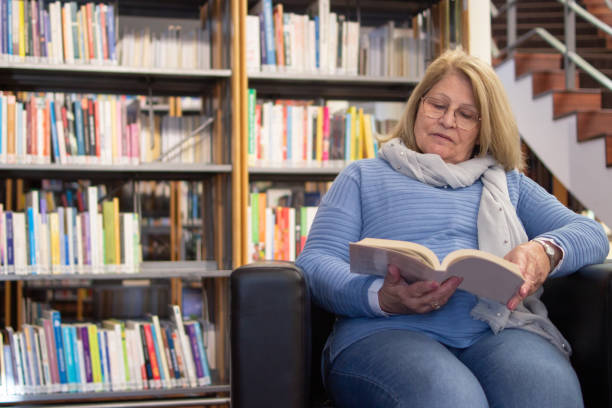 istock Serious aged woman reading books after courses 1451902778
