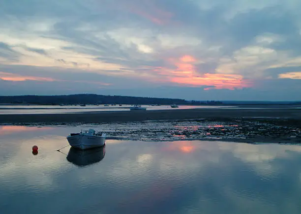 A fishing boat  at low tide at sunset