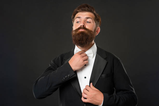 istock bearded groom in tuxedo on black background, suit 1451904588