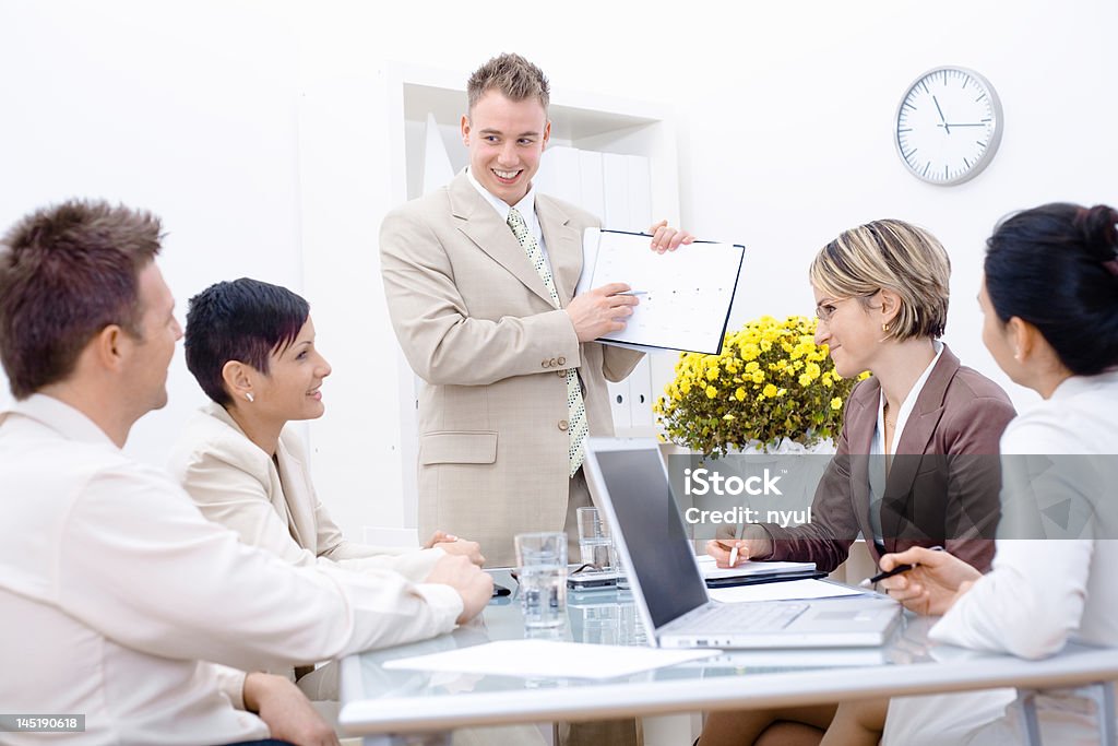 Business Meeting Young and happy businesspeople having meeting in board room, smiling. Adult Stock Photo
