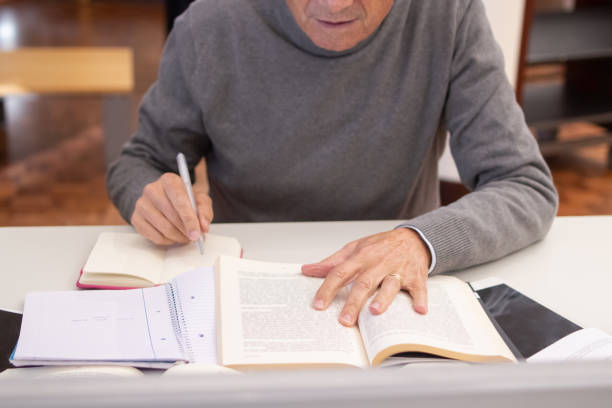 istock Close-up of serious aged man making notes with pen 1451906430