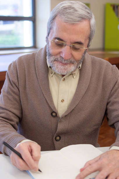 istock Close-up of positive senior man spending day in library 1451906451