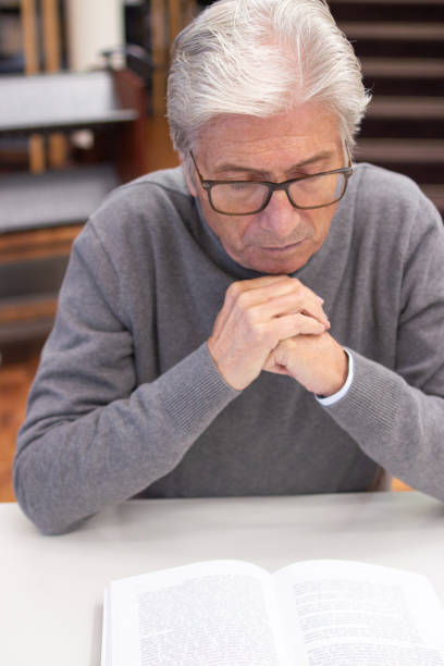 istock Close-up of aged man reading book with interest 1451906508