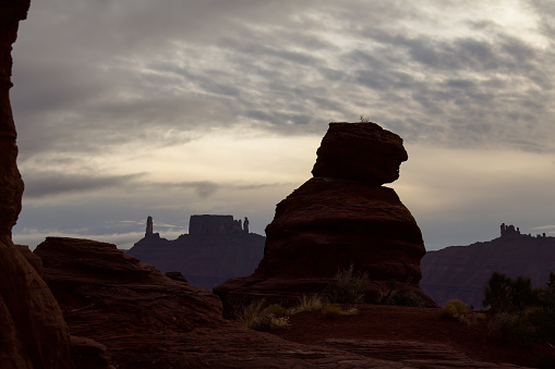 Dramatic cloudy skies with rock formations resembling an old man in the desert