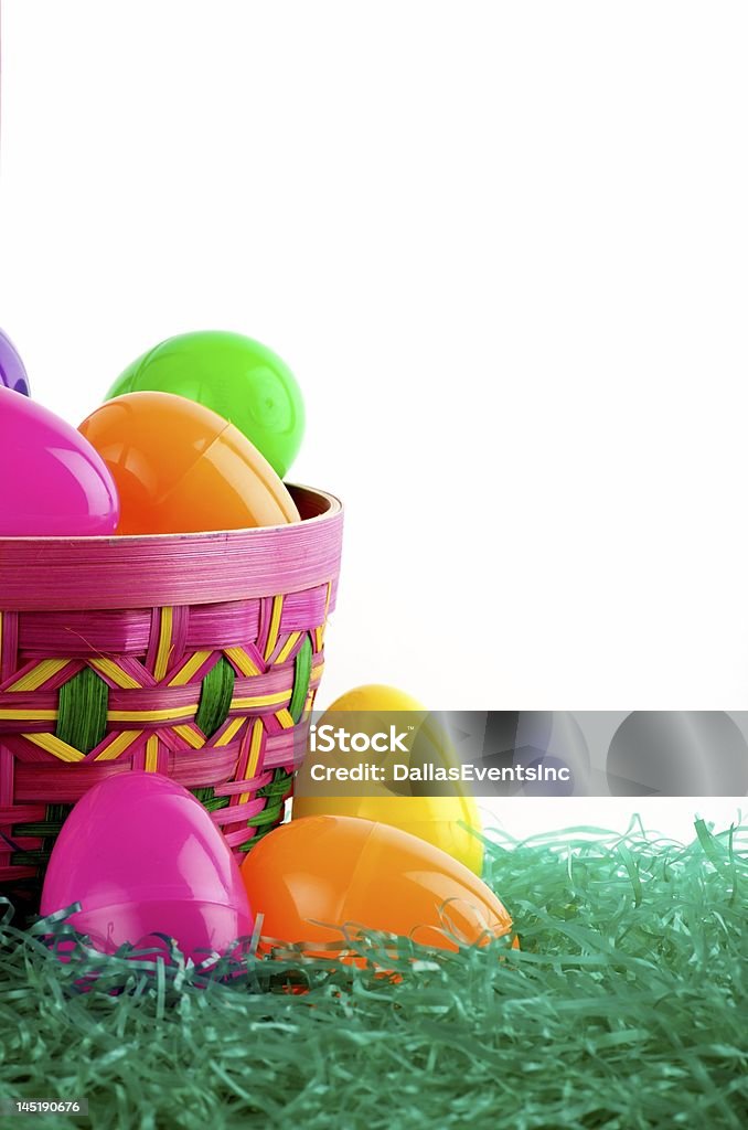 Colorful basket of Easter eggs Image of a colorful Easter basket with colored eggs on green with white background Backgrounds Stock Photo