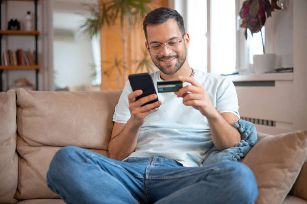istock Man using his credit card to shop online 1451909447