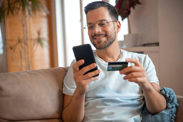 istock Man using his credit card to shop online 1451909499