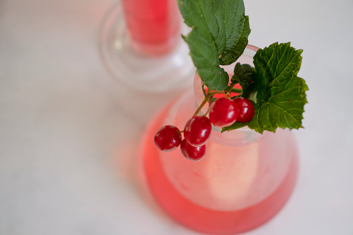 Laboratory flask viburnum berries on a light background
