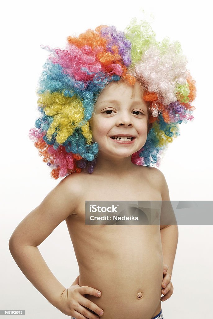 Boy in colorful wig standing his hands on hips Boy in colorful bright wig standing his hands on his hips Child Stock Photo