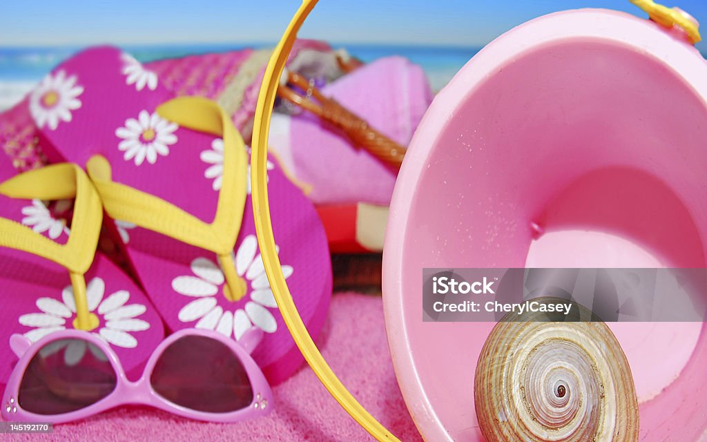 Beach Accessories Pink sand pail, flip-flops and sunglasses on beach Animal Shell Stock Photo
