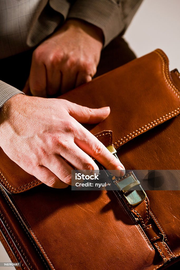 Hand opening briefcase Business man opening elegant brown leather briefcase. Last Day Stock Photo