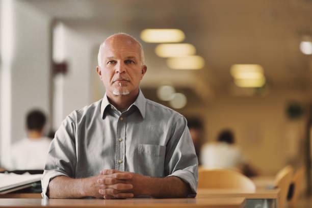 istock Middle-aged man sitting with intertwined hands among other blurr 1451929138
