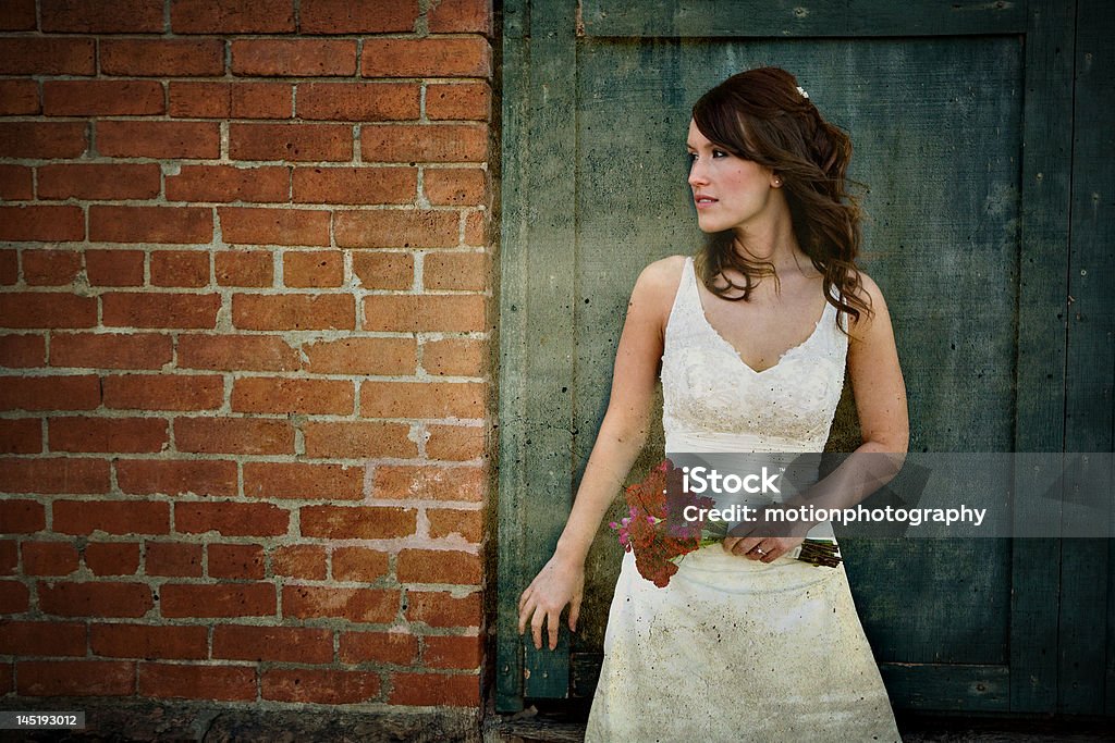 Urban Bride Bride poses in front of grungy wall Wedding Stock Photo
