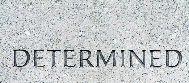 istock Word "Determined" Carved in Gray Granite 145193249