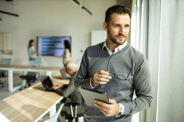 istock Confident young man businessman working inside modern office on a digital tablet 1451933035