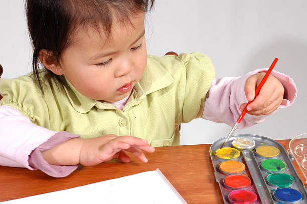 little girl painting stock photo