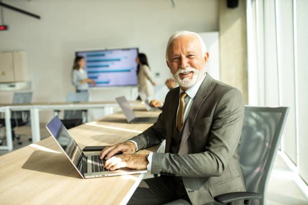 istock Senior businessman working on laptop computer inside modern office 1451935083