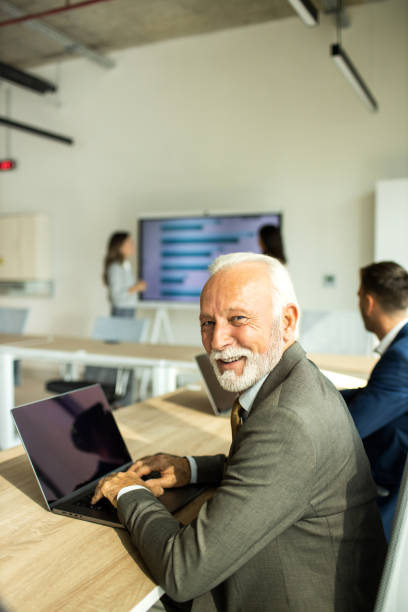 istock Senior businessman working on laptop computer inside modern office 1451935084