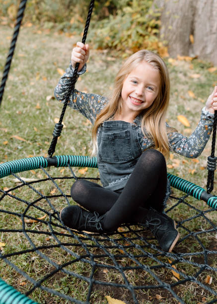 istock Happy girl playing on swingset 1451935128