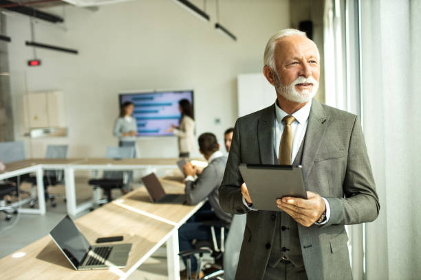 istock Confident senior man businessman working inside modern office on a digital tablet 1451935227