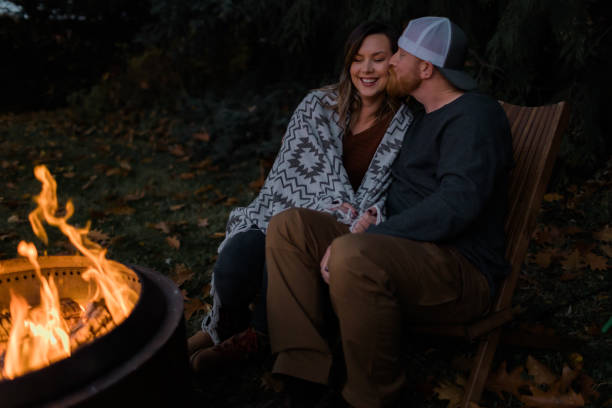 istock Husband and wife relaxing next to a fire outside 1451935268