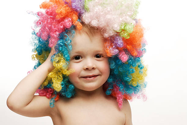 istock Little boy in colorful bright wig holding his head laughing 145193746