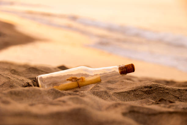 istock Message in a Bottle on Sand at Sunset 1451943915