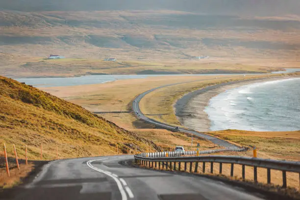 Empty road trough Iceland near the sea on a beautiful sunny autumn day.