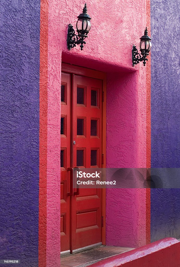 The Red Door  Purple and pink wall with a red double door. Black Color Stock Photo