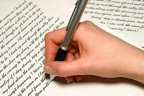 istock Hand holding a pen and writing on paper 145195333